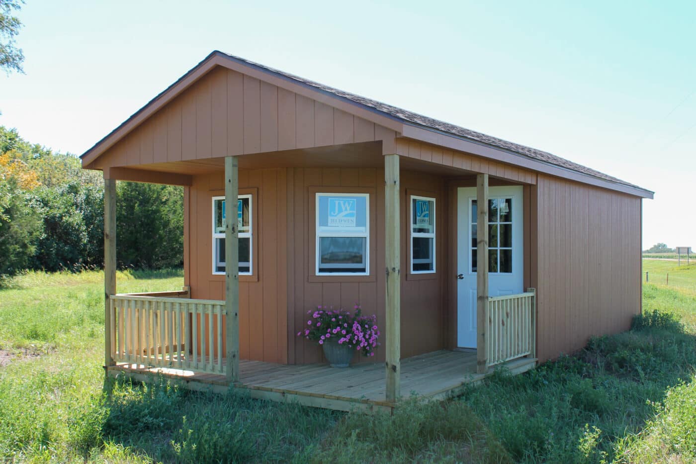 Cabin shed with orange siding and a front porch