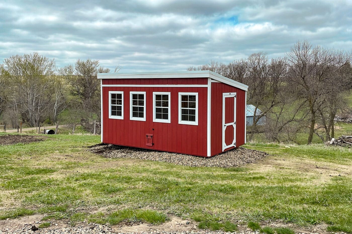 Red chicken coop shed in filed
