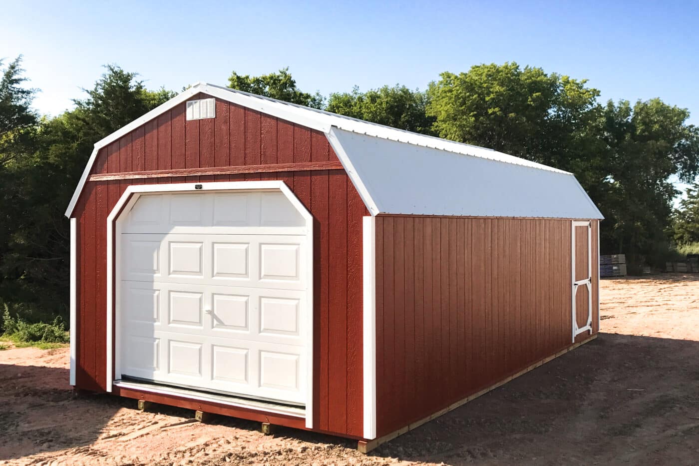 Red high barn prefab garage shed in field