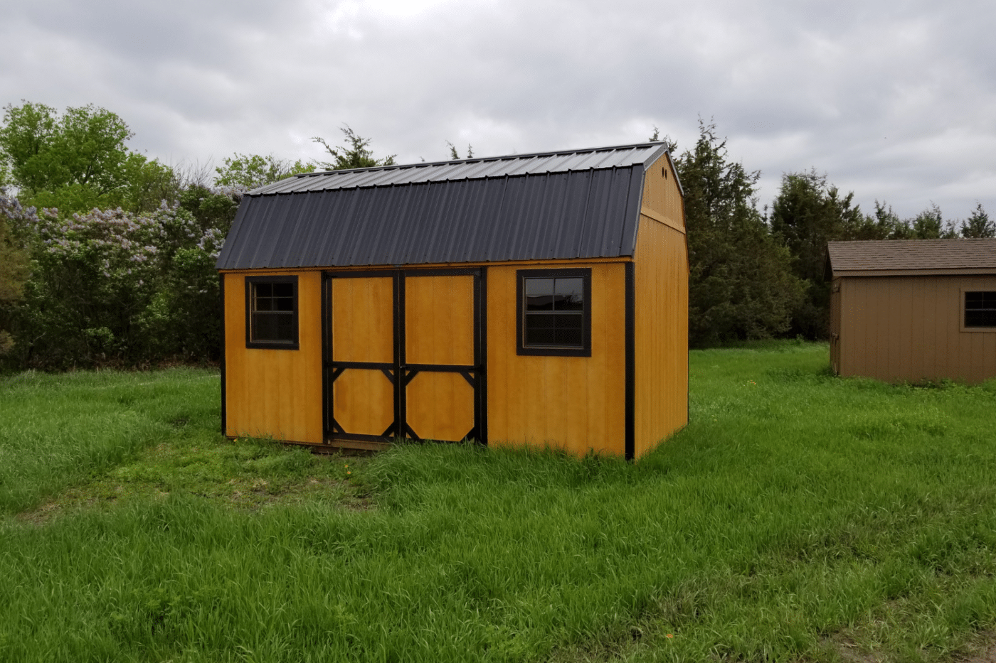wooden and black high barn shed in field in brandon sd