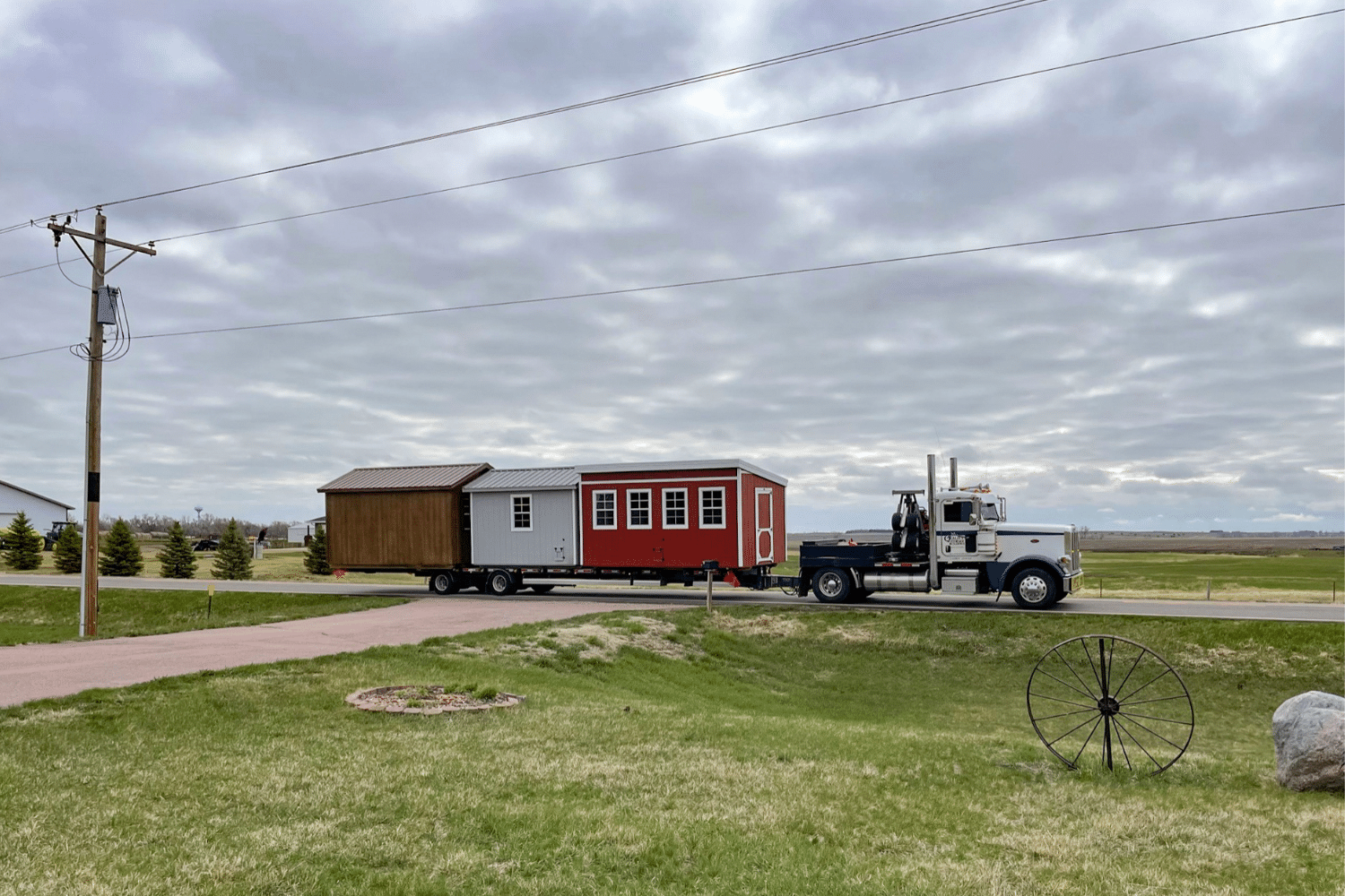 truck carrying three sheds for shed delivery in hartford sd