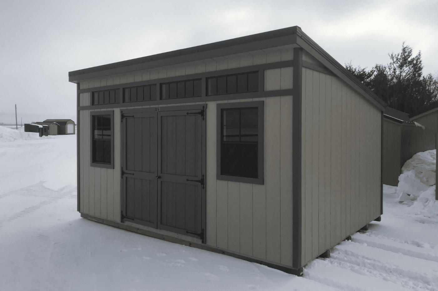 grey studio shed in hartford sd in snow